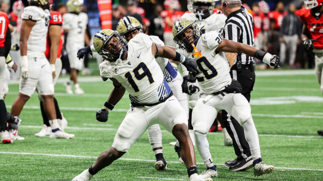 Thomas County Central's Walter Reddick (19) and Caleb Anderson (20) celebrate another big play by the Yellow Jackets roster. The two combined for 2-1/2 of the team's 10 sacks. 12/12/2023